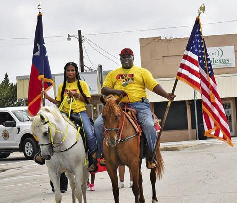 ROGER AND RACHEL Richmond display the American and Texas flags at the Juneteenth Parade on Saturday in downtown Caldwell.