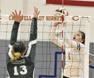 CALDWELL’S ASHLYN KELLUM pushes the ball over the net and over Taylor’s Camryn Nunamaker during the Lady Hornet-Lady Duck match on Friday afternoon. -- Tribune photo by Roy Sanders