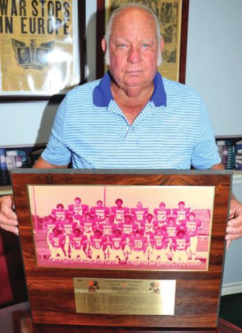 VANCE McMANUS HOLDS this plaque honoring the 1980 Caldwell Hornets district champions. -- Tribune photo by Roy Sanders