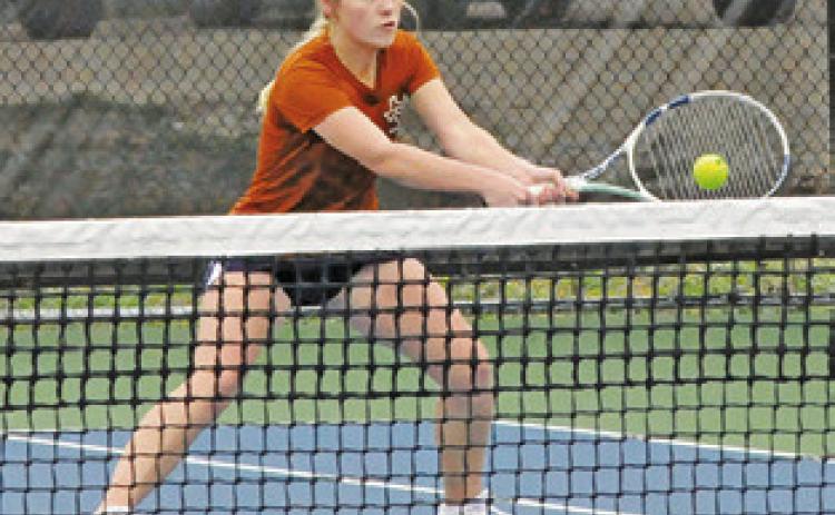 JORDAN PERKKIO volleys at the net during a mixed doubles match last Friday at the Caldwell Invitational Varsity Tournament.