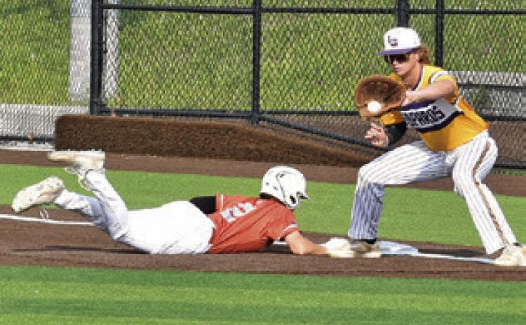 CADEN SCHLUENS SLIDES back into first base last Friday against La Grange. The Hornets won 8-3 and are headed to the playoffs. Tribune photo by Roy Sanders
