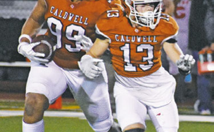 DELVIN MORRIS of Caldwell carries the ball as Thomas Willard prepares to block.