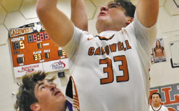 KOY MACIK of Caldwell leaps high for this shot last Friday against Navasota. Tribune photo by Roy Sanders