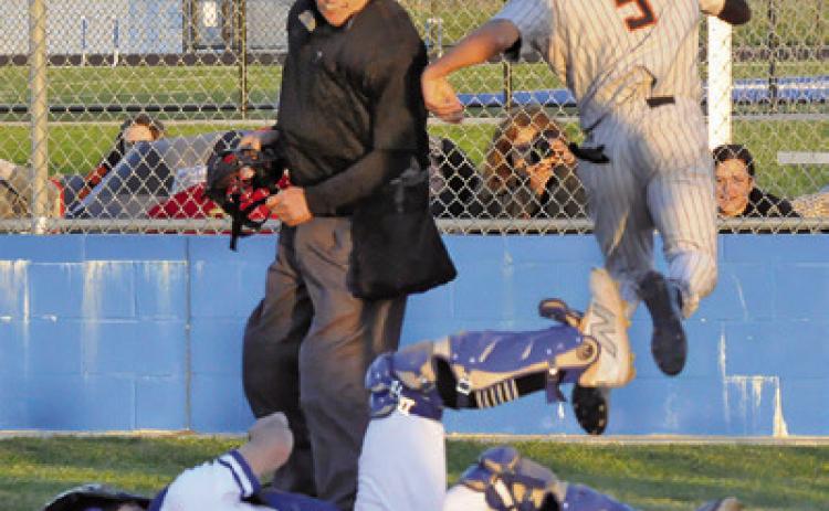 SOMERVILLE’SKYLEBROOKS leaps high at home plate to get around Snook catcher Jordan Price. -- Tribune photo by Denise Squier