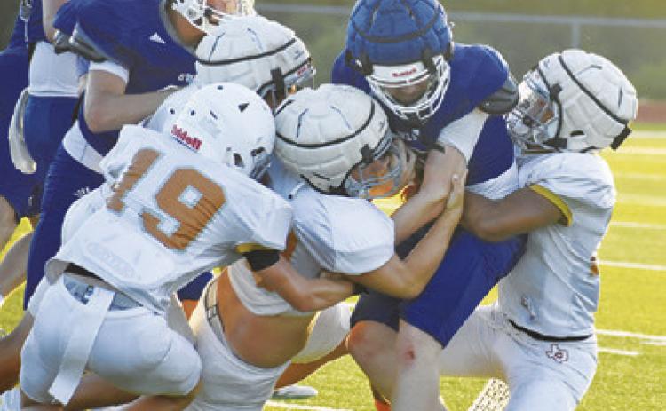 THE CALDWELL DEFENSE gang tackles this Anderson-Shiro ball carrier in the Aug. 13 scrimmage in Caldwell. Tribune photo by Roy Sanders