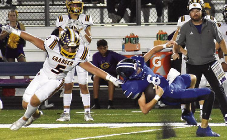 SNOOK QUARTERBACK BRETT Withem falls as this Granger defender approaches in last Friday’s game in Snook. Tribune photo by Roy Sanders