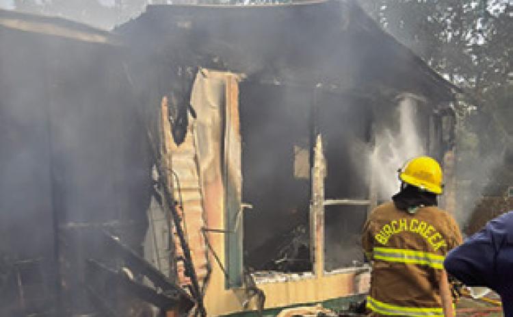 A BIRCH CREEK firefighter battles this house fire last Friday at Shady Oaks Drive at Somerville Place Subdivision. Photo courtesy of Birch Creek VFD.