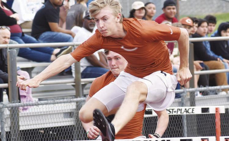 CALDWELL ATHLETE Daniel Cowan clears a hurdle during last week’s Skrabanek Relays in Caldwell. Also pictured is Corbin Stewart.