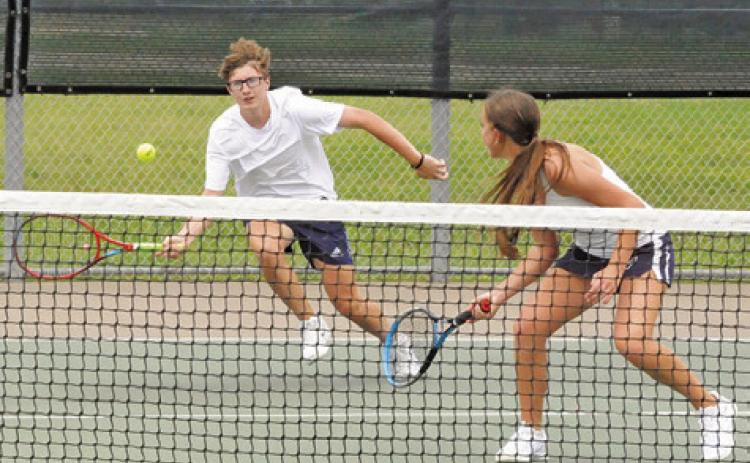 CALDWELL’S CAYDEN ZBORIL runs to return the ball as his mixed doubles teammate Kylie Vogler looks on during their first round match at last week’s Class 4A Region 3 Tennis Tournament in Bryan.