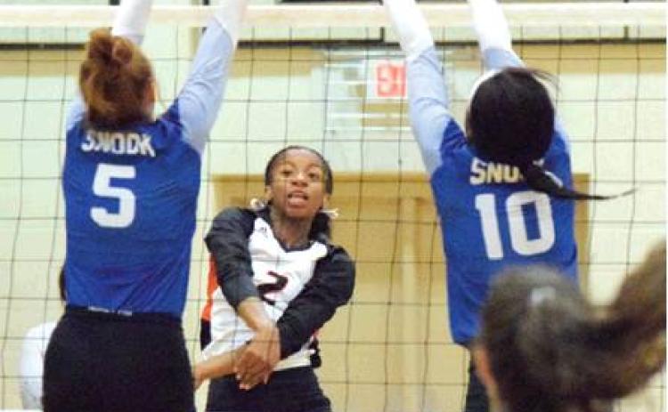 SOMERVILLE’S RAMAYA CARTER hits the ball through the block of Snook’s Kenzie Kmiec. Also pictured are Snook’s Jaivan Stringfellow and Natalie Vacha. -- Tribune photo by Denise Hornaday