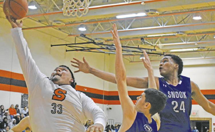 SOMERVILLE’S JESUS ESPINOZA shoots as Snook’s Josh Green and Dekendrick Dawson defend. -- Tribune photo by Roy Sanders