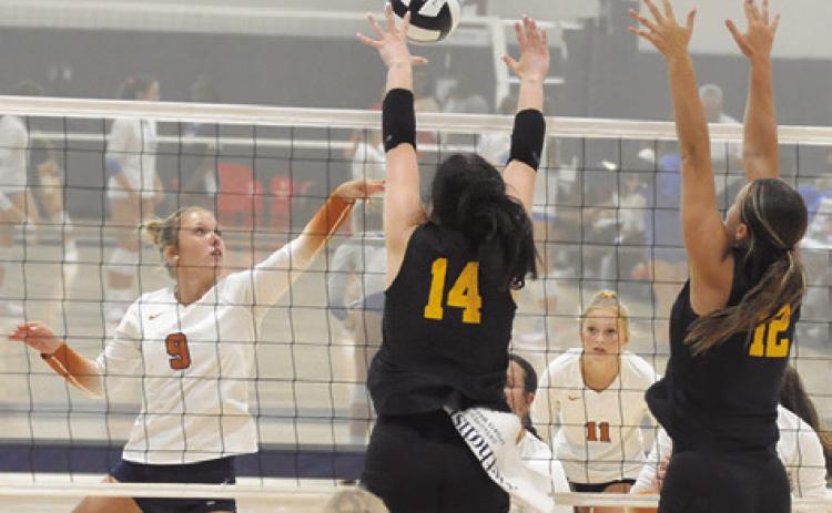 CALDWELL’S MOLLY MEADOWS hits the ball into the hands of Klein Oak’s Tori Leggeiro and Ava Marr during Caldwell’s match against Klein Oak at last week’s Legends Invitational tournament. Tribune photo by Denise Squier