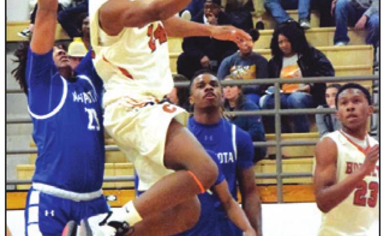CALDWELL’S JUNIOR Mathis goes airborne to score a basket during the Caldwell-Navasota game. -- Tribune photo by Denise Hornaday
