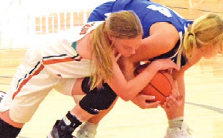 CADIE COSTON BATTLES for possession of the ball during the Caldwell-Victoria St. Joseph basketball game last week.