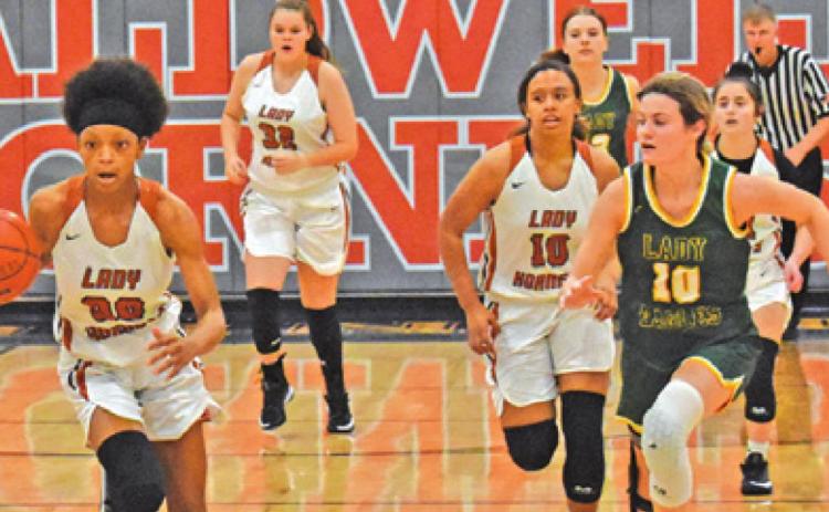 CALDWELL’S JAE MATHIS drives down the court during the Lady Hornets’ win over Lexington last Friday. Also pictured is Ava Jones.