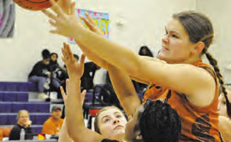 RILEY BROADDUS reaches over several Lady Jays for possession of the ball during the Caldwell-Snook game last week during the Lady Hornet Basketball Tournament.