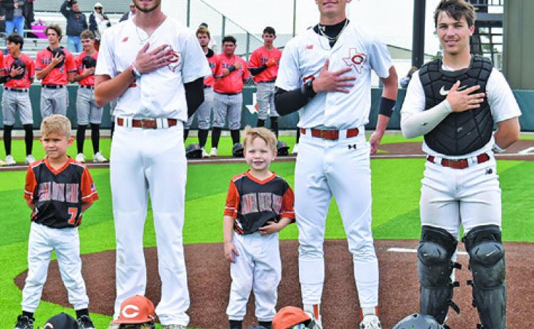 CALDWELL’S CORT HILDEBRAND, Shane Clements and Jake Hibbeler are joined by these Little League players, and future Hornets, for the National Anthem at the Caldwell-Smithville game on Saturday. Tribune photo by Roy Sanders