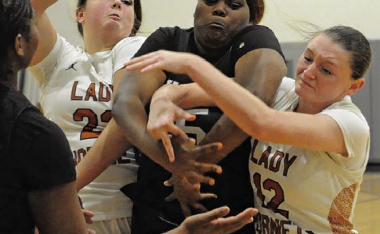CALDWELL PLAYERS, Kierstyn Macik and Kaely Brown, fight with a Hearne player for possession of the ball during Caldwell’s 44-31 win over Hearne last Tuesday night in Hornet Gym. Tribune photo by Denise Squier