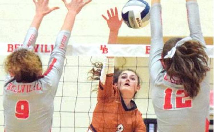 CALDWELL’S CORINNE DILLARD hits the ball through the arms of Bellville’s Sadie Mckay and Madison Morgan Friday night during the Lady Hornets four-set win. -- Tribune photo by Denise Hornaday