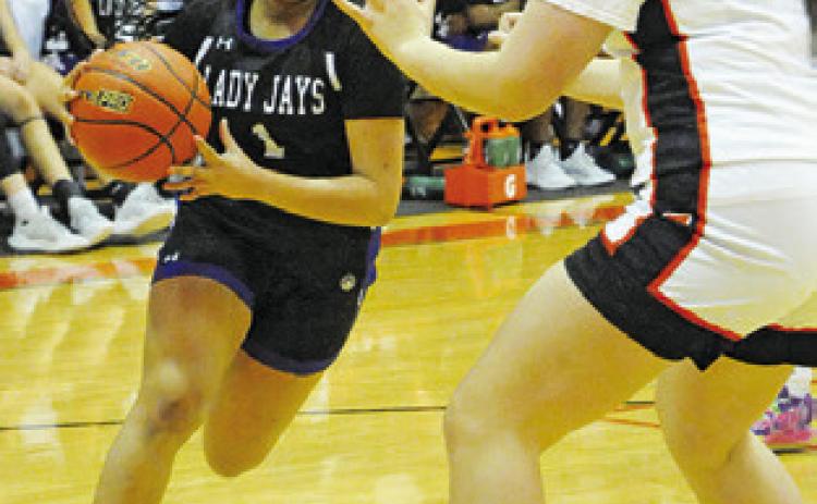 ALANA STRINGFELLOW drives to the basket while Gracee Greiffenstein defends during the Snook-Somerville game last Tuesday. Tribune photo by Denise Squier