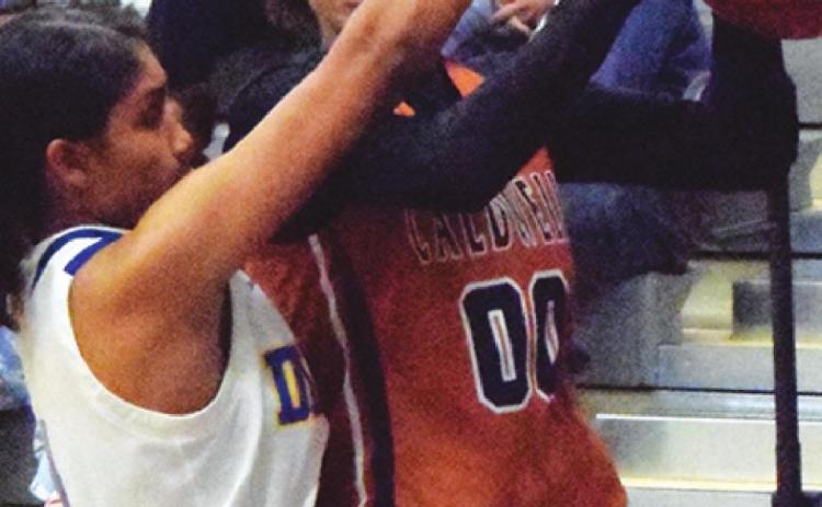JAE MATHIS IS FOULED while driving the baseline during the Caldwell-Dime Box basketball game last Friday in Dime Box.