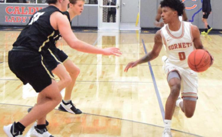 CALDWELL’S LARRY DAVIS drives down the court while two Rogers’ players defend during last Tuesday’s home district game.