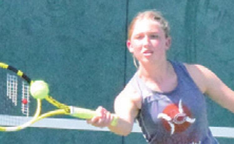 CALDWELL’S TILLY Hicks returns serve during a girls doubles match in Franklin last Thursday. -- Tribune photo by Denise Squier