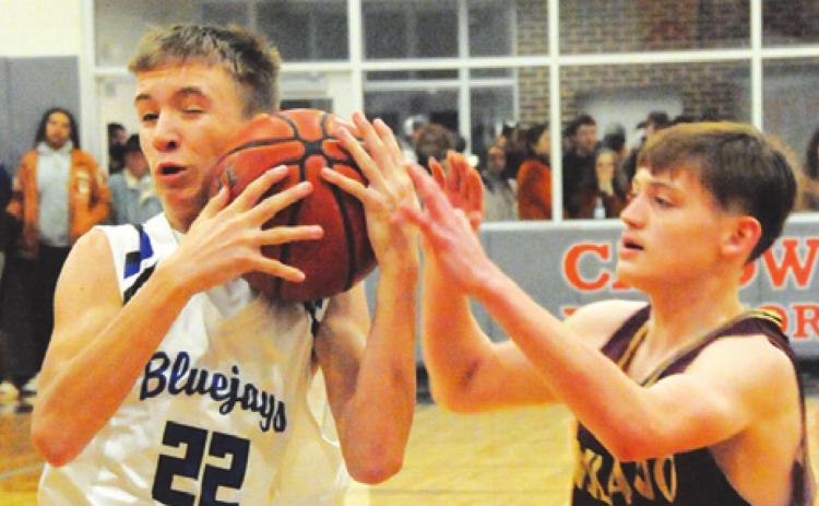 SNOOK’S BRETT WITHEM fights with Milano’s Mykal Hutson for possession of the ball during the Bluejays-Eagles area round battle last Friday night in Caldwell. -- Tribune photo by Denise Squier