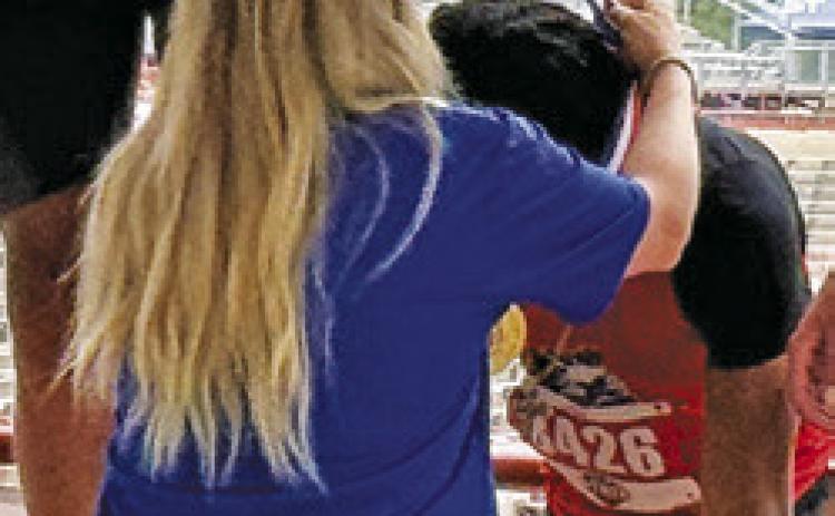 JEREMY VELA is draped with his gold medal by a UIL official at the UIL State Track &amp; Field Meet in Austin last week. Tribune photo by Denise Squier