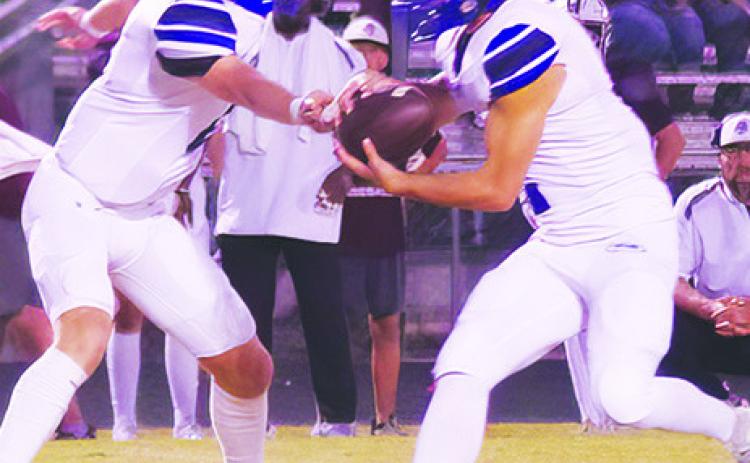 SNOOK’S BRETT Withem hands off to Tristan Yen in the Iola game last Friday. Photo courtesy of Steve Ingram