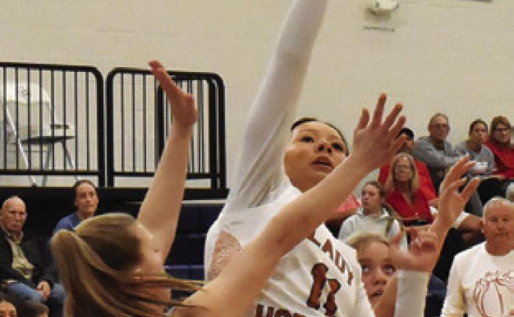 CHASSIDY ROGERS attempts a layup over Bellville’s Addison Hollomon during the Lady Hornets’ home loss on Friday. Tribune photo by Roy Sanders