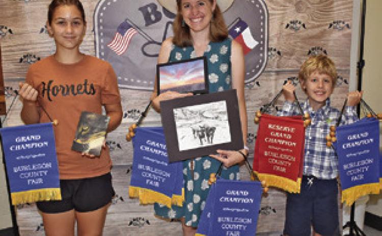 JENNA DODSON, CENTER, won grand champion for oil on canvas; Ivy Chatwin, left, won grand champion for pencil drawing, pastel painting, pen and ink drawing, acrylic painting, embroidery, needlework-crochet, and unusual horticulture project; and Rory Chatwin, won grand champion for woodwork, shrubbery, unusual horticulture project, foliage-potted plants, fruits and vegetables and recycled arts and crafts.
