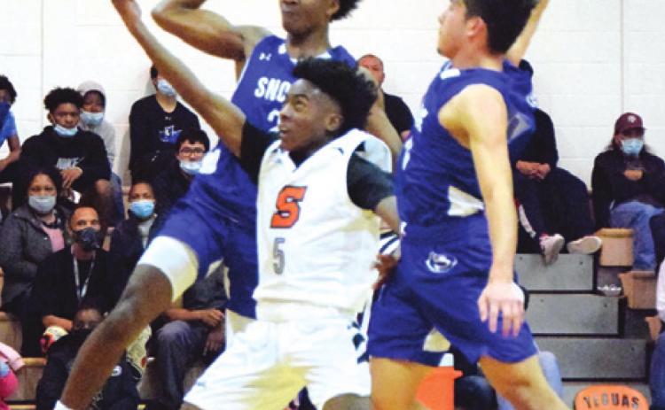SOMERVILLE’S VERKOBE WOODBERRY shoots with Snook’s Jermaine Kearney and David Davila defending during the Yegua-Bluejay game last Tuesday night. -- Tribune photo by Denise Squier