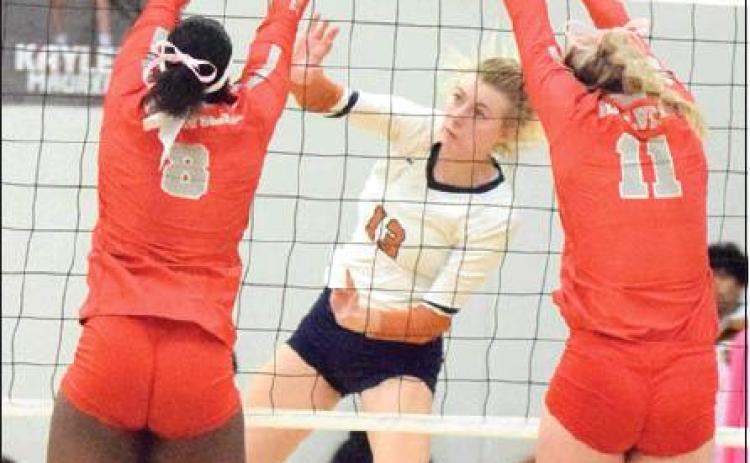 CALDWELL’S MARLEY MAURER hits the ball past Bellville’s Kearstin Carter and Robbin Rice during the Lady Hornets’ loss to the Brahmanettes on Friday. -- Tribune photo by Denise Hornaday
