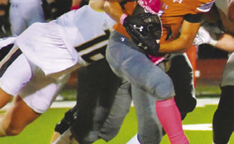E.J. ROGERS fights through this Giddings defender for yardage last Friday in Caldwell. -- Tribune photo by Roy Sanders