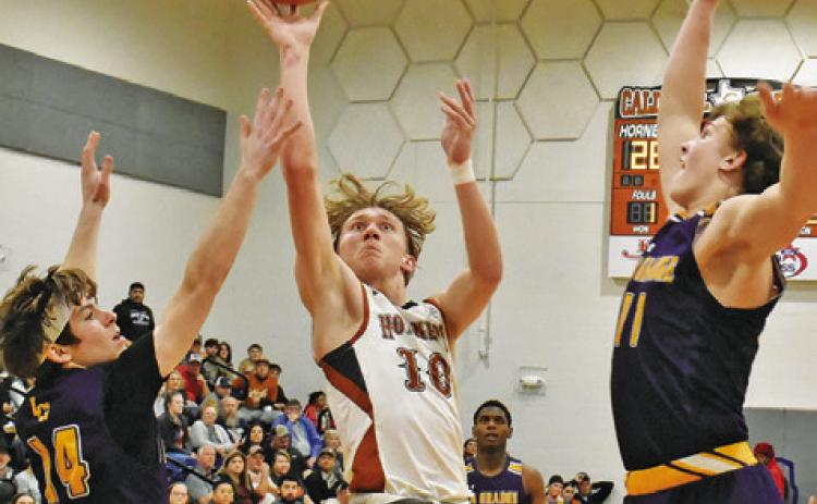 TRAVIS CUNNINGHAM OF Caldwell leaps high for this shot as La Grange defenders try to block it. -- Tribune photo by Roy Sanders
