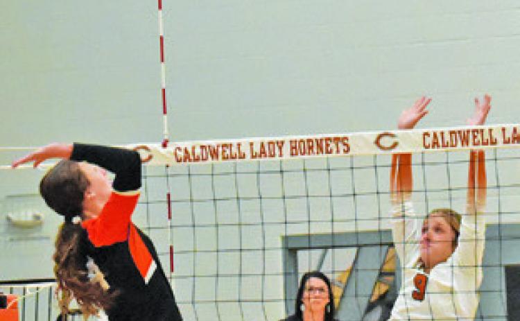 CALDWELL’S MOLLY MEADOWS leaps to attempt a block during the Lady Hornets’ win over Smithville on Friday at Hornet Gym. Tribune photo by Roy Sanders