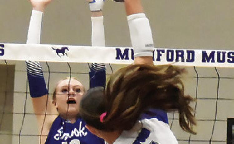DAKOTA KIENOW attempts to block a hit from a Mumord player during Friday’s match. Tribune photo by Roy Sanders