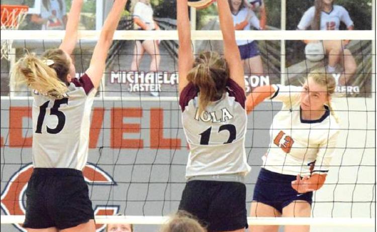 THE LADY HORNET VOLLEYBALL TEAM had a great 2019 season, finishing with a 43-6 record and a regional final berth. The team tops this year’s sports stories for 2019. Pictured is Marley Maurer hitting the ball through an Iola blocker. -- Tribune photo by Denise Hornaday