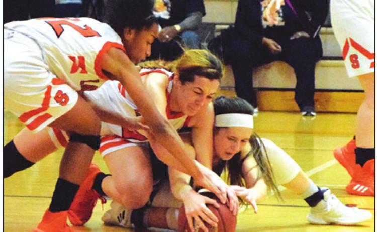 SOMERVILLE’S RA’MAYA Carter and Maddie Knox fight for possession of the ball with Snook’s Riley Green during their battle for first place in District 26-2A Friday. -- Tribune photo by Denise Hornaday