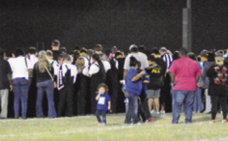 FANS, PLAYERS AND COACHES come onto the field to pray for Bartlett’s Frankie Gonzales. Gonzales was injured during the game and transported by ambulance to an area hospital.