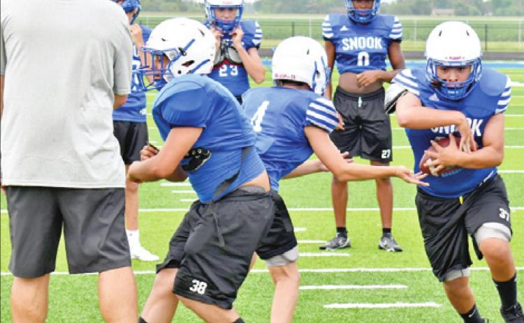 FULLBACK JACOB CASTANEDA takes the handoff from quarterback Caden Schluens. Also pictured is left guard Richard Santillan. The Bluejays are getting ready for the 2021 football season.