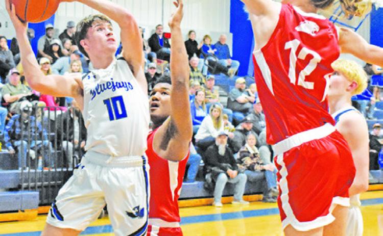 LANCE LARA OF Snook jumps high for this shot despite some defensive pressure from Burton. -- Tribune photo by Roy Sanders