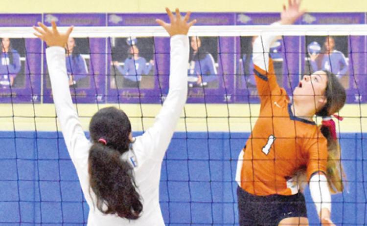 CALDWELL’S ASHLYN KELLUM reaches to hit the ball for one of her 20 kills against Rockdale last Friday. -- Tribune photo by Roy Sanders