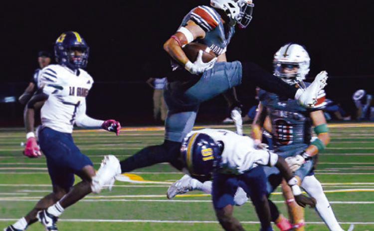 COY BECKA OF Caldwell leaps over this defender in the Hornets’ game against La Grange last Friday night. Tribune photo by Kim Hutcheson