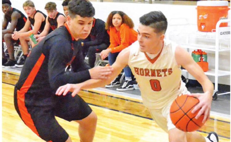 BOBBY LAROUAX DRIBBLES the ball past this Smithville defender on Friday, Jan. 17, in Caldwell. The Hornets won their district opener 60-38. -- Tribune photo by Roy Sanders