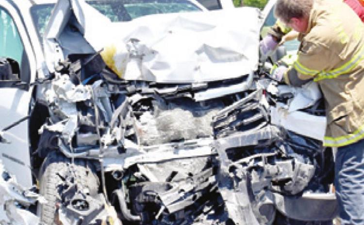 FIREFIGHTERS WORK the scene of this accident on Saturday off State Highway 21 East.