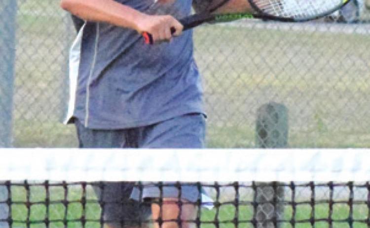 WAYLON CHAPMAN rushes to the net to return the ball during his boys’ singles match in Bastrop. -- Tribune photo by Denise Hornaday