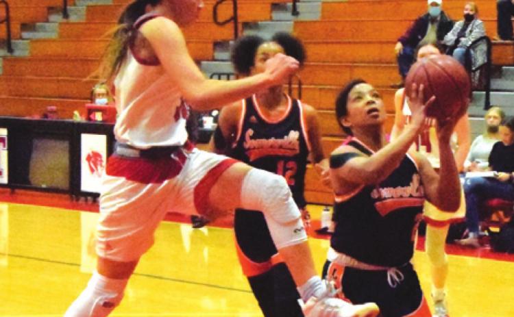 SOMERVILLE’S JAZMINE JACKSON is about to be fouled by Deweyville’s Emilee Totino during the Lady Yeguas’ bi-district game last Thursday night in Tomball. -- Tribune photo by Denise Squier
