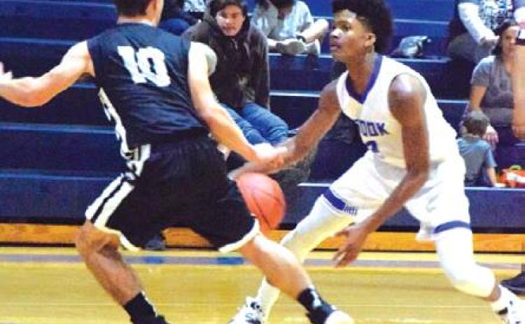 SNOOK’S JERMAINE KEARNEY tries to dribble past Moulton guard Braden Kram during the Snook-Moulton game last Tuesday night at Snook High School. -- Tribune photo by Denise Hornaday